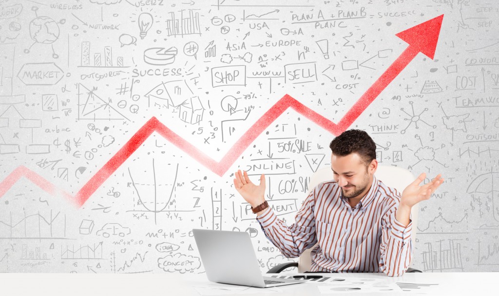 Business man sitting at table with market diagrams