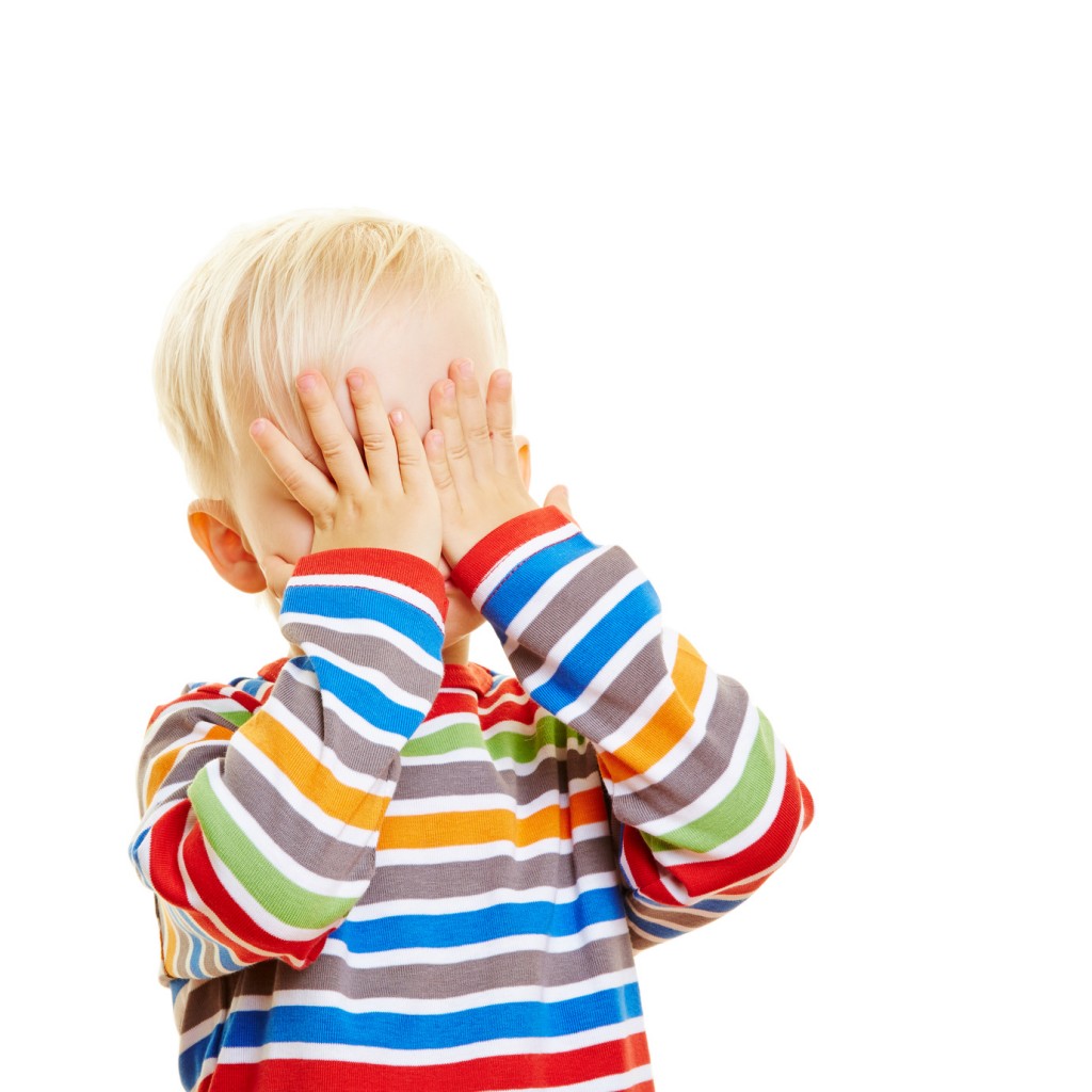 Kind hält sich die Augen zu